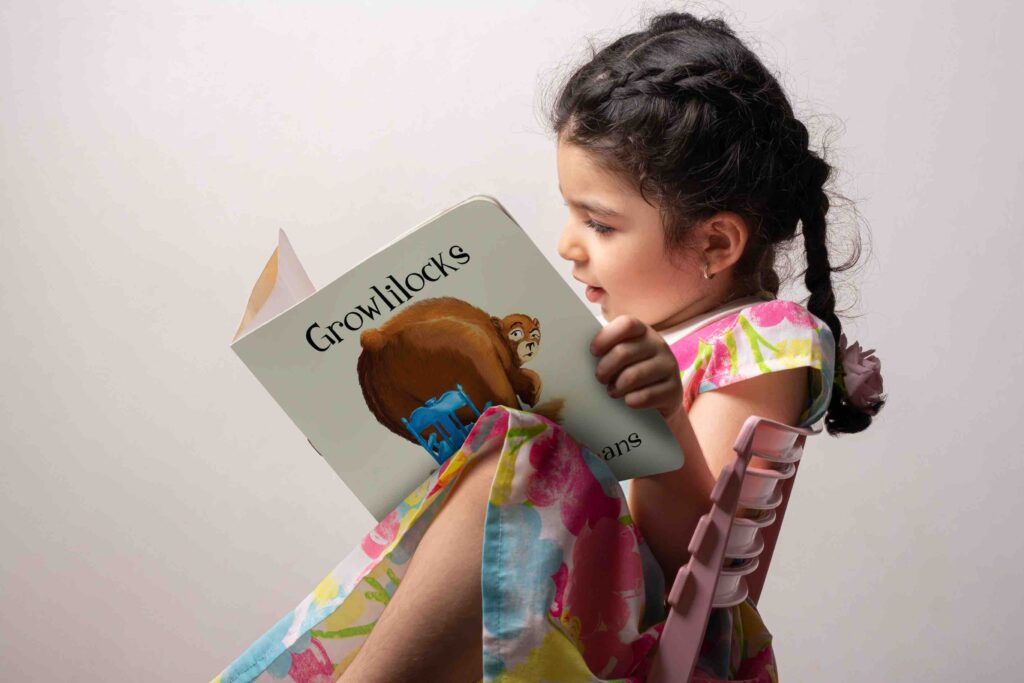 Little girl reading a story book with blank cover in front of body mock-up series 392